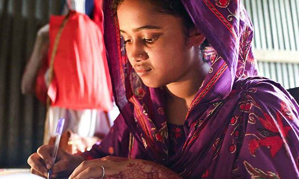 Mitu fra Bangladesh driver med skolearbeid.