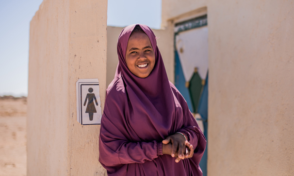 Jente står fremfor jentetoaletter utendørs i Somalia