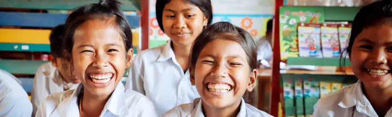 Jenter smiler på skolen 