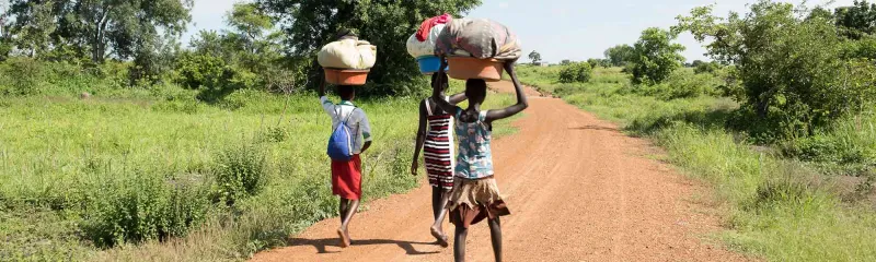 Tre jenter på vei til elva for å vaske klær i Sør Sudan