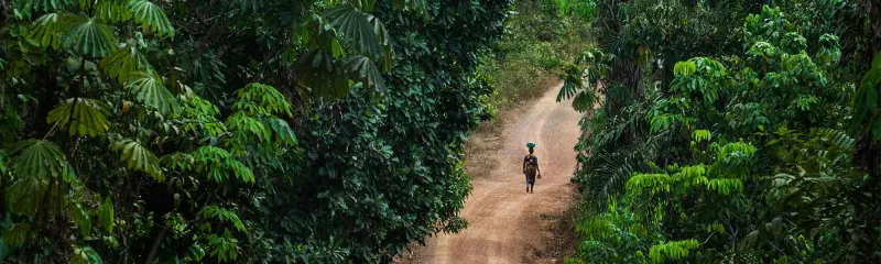 Kvinne på en øde vei i en skog i Liberia