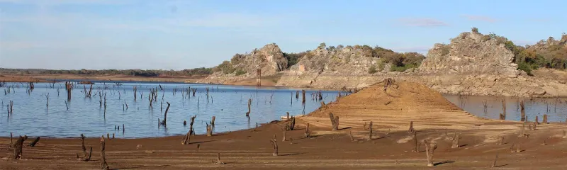 Sola skinner over en innsjø i Zambia