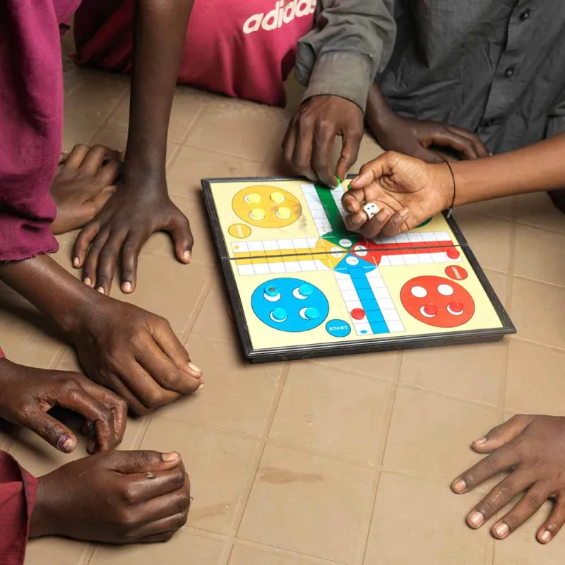 Barn spiller Ludo på et av Plans trygge områder.