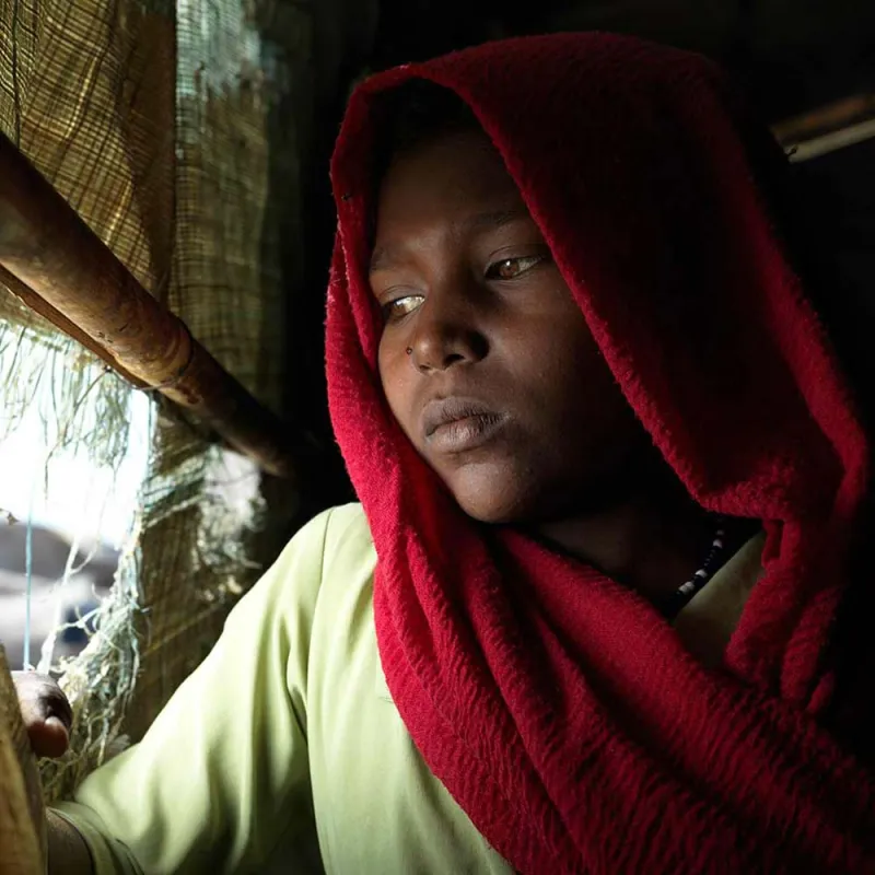 Jente i Sør Sudan ser ut gjennom en glippe i teltet