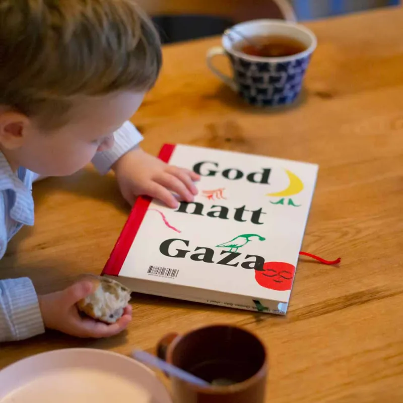 Gutt som ser på boken God natt Gaza